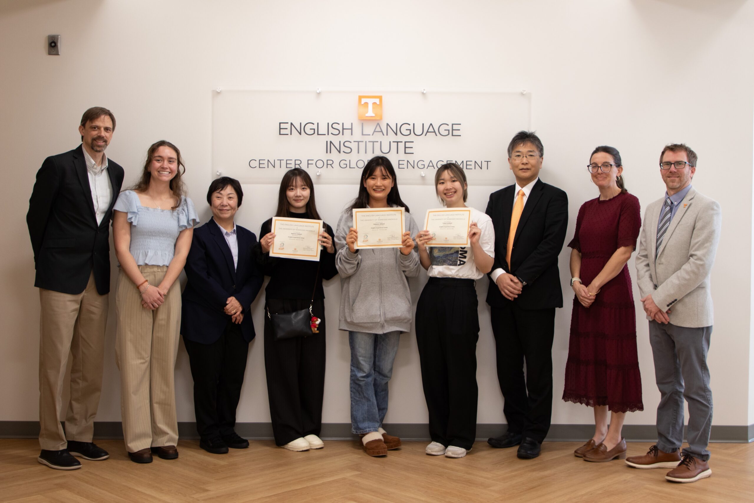 Japanese university students receiving their program certificates at the English language institute